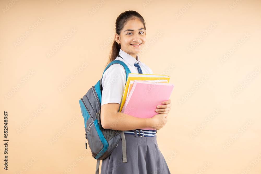 Happy Indian student modern schoolgirl wearing uniform holding books ... Happy Indian student modern schoolgirl wearing uniform holding books ...